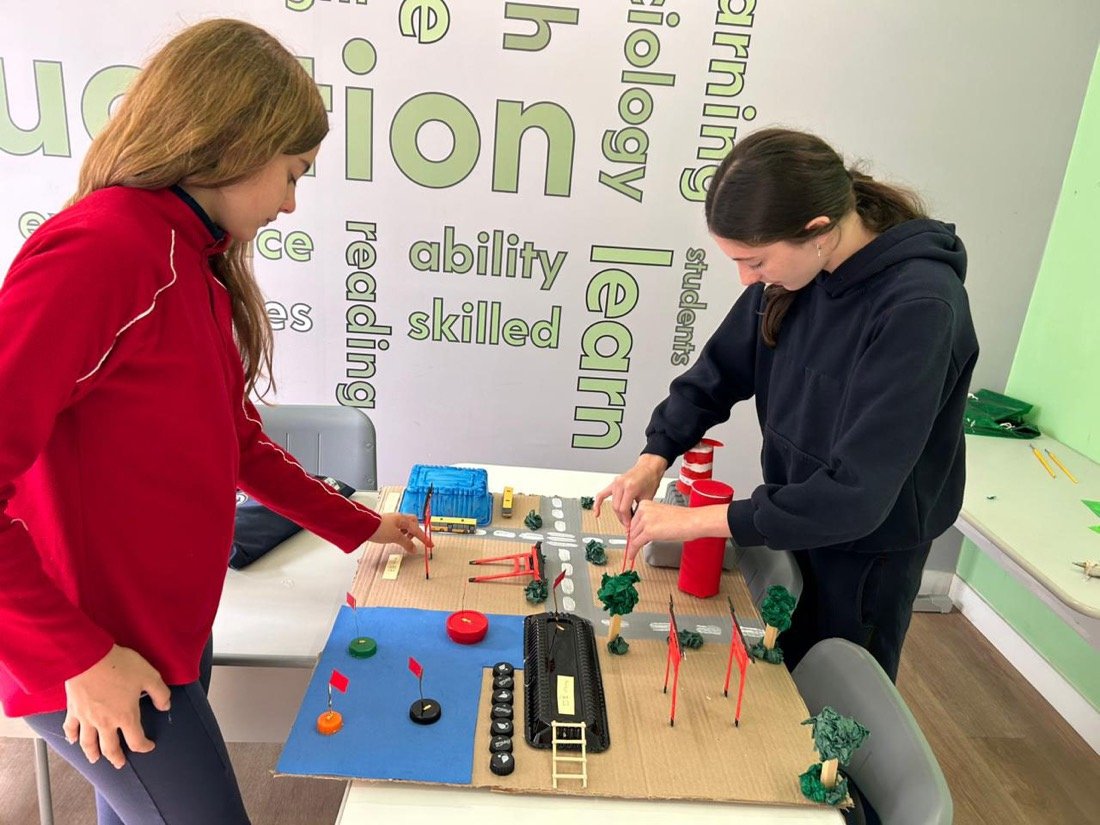 Alunas do Business Discoveries construindo uma maquete em projeto em inglês